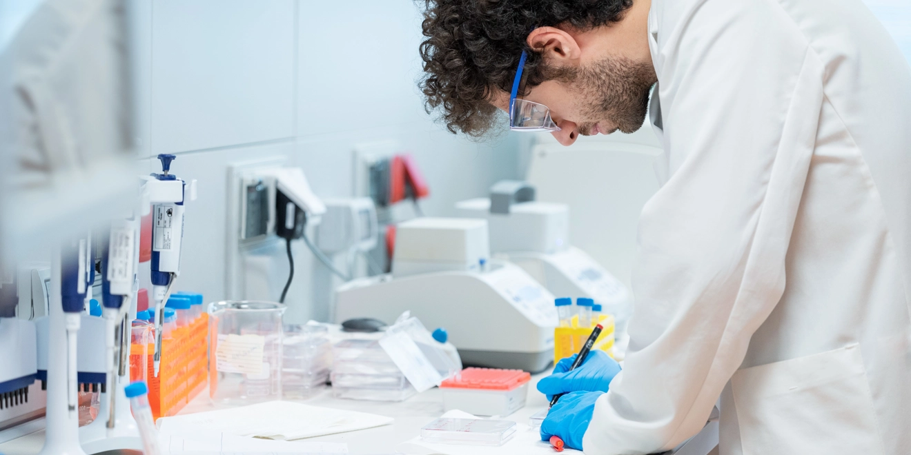 Un scientifique écrit sur une feuille dans un laboratoire