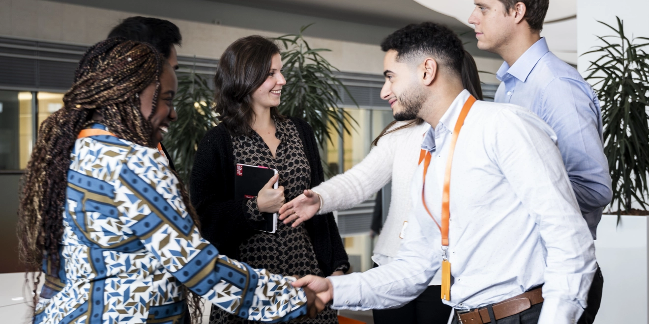 Young GSK colleagues meeting and shaking hands